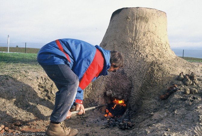 Bas fourneau réalisé dans le cadre d'une journée d'expérimentation de la métallurgie du fer en novembre 1999 à Montargis (Loiret).  La porte du bas fourneau est ouverte afin de faciliter l'écoulement de la scorie en fusion. 