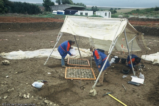 Enregistrement par carroyage et relevé de l'un des ateliers de taille du campement mésolithique final de La Presle à Lhéry (Marne), 2001.  La fouille fine a permis de dégager des milliers de fragments de silex.