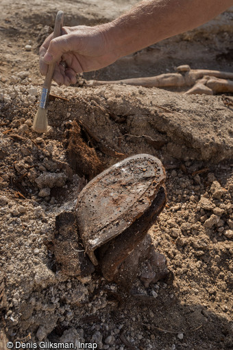 Chaussure militaire découverte sur le site du cimetière allemand de la Grande Guerre de Boult-sur-Suippe, Marne (2016). Contrairement au règlement allemand qui préconise la récupération des effets militaires, les défunts morts au combat portent encore leurs uniformes (vareuse, pantalon, sous-vêtements et bottes) et leur équipement (casque, ceinturon et cartouchières, masques à gaz...). 