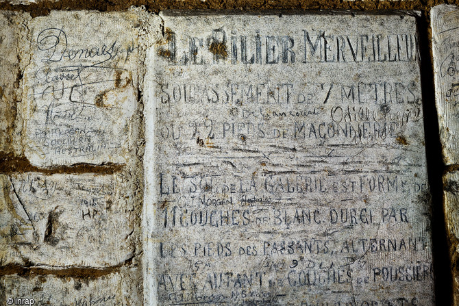 Inscriptions retrouvées dans les grottes souterraines de Naours (Somme).  Ces inscriptions ont été faites à l’occasion de la redécouverte du site en 1886 (le site date du XVe s.) par l’abbé Danicourt et qui servait à guider et à renseigner les visiteurs et les touristes dès 1888, Naours (Somme), 2015.