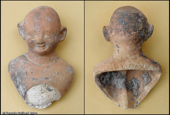 Statuette en terre cuite repr&eacute;sentant Risus, le buste de l'enfant rieur reposait sur un socle circulaire.