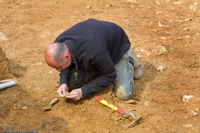 Archéologue dégageant une concentration de silex taillés sur le site du Paléolithique moyen récent (entre 110 000 et 70 000 ans) à Tigery (Essonne), 2016