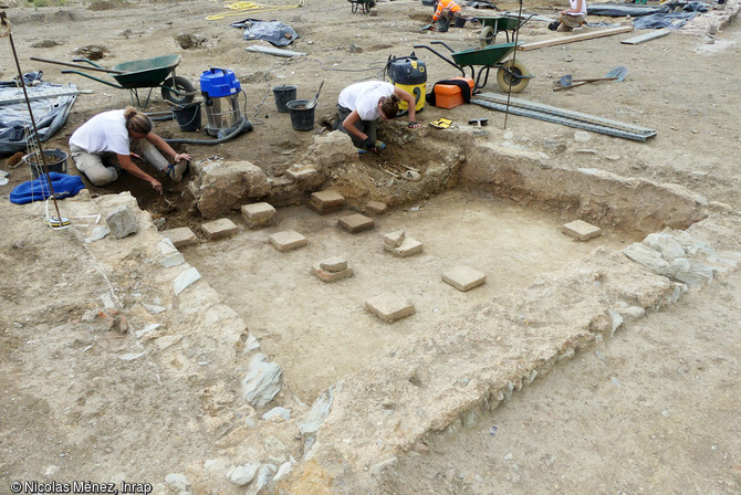 Fouille en cours d'une salle sur hypocauste (système de chauffage par le sol) de la domus d'un riche notable sur le site gallo-romain de l'hôtel-dieu à Rennes (Ille-et-Vilaine), 201. Cette domus disposait de plusieurs cours, de sols en béton. Ses murs, réalisés en blocs de schiste sont montés au mortier de chaux.