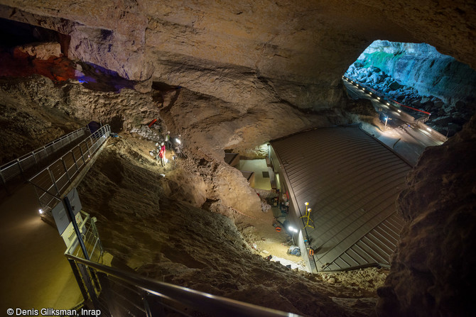 Galerie principale de la  salle du théâtre  de la grotte préhistorique du Mas-d'Azil (Ariège), 2015.  Devant le bâtiment l'équipe de fouille évalue l'extension des niveaux archéologiques aurignaciens. Plus haut dans la pente, les archéologues ont pu mettre au jour des lambeaux de niveaux archéologiques magdaléniens moyens. 