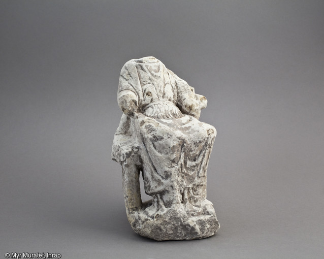 Statuette en calcaire, IIe-IVe siècle, hauteur 15,1 cm, découverte dans le sanctuaire du site de la ZAC du Clos de la Fontaine de l'Étuvée à Orléans (Loiret). Il s'agit d'une déesse mère ou une déesse Abondance. Les mains, la tête et un pied du fauteuil ont disparu avant l'enfouissement volontaire dans une fosse aménagée. Ces enfouissements volontaires d'objets liés au culte montrent que ces derniers, désormais non-utilisés, ne sont pas pour autant désacralisés et restent attachés au sanctuaire. 