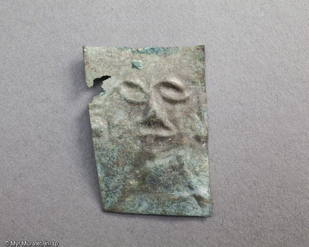 Ex-voto en tôle de bronze martelée représentant un visage, Ier-IIe siècle, mis au jour dans le sanctuaire du site de la ZAC du Clos de la Fontaine de l'Étuvée à Orléans (Loiret). Plutôt que d'y voir une représentation de la divinité, c'est sans doute l'image même du dédicant s'adressant à son dieu qu'il faut ici considérer. Les ex-voto sont des objets déposés dans le sanctuaire, soit à titre de supplique, soit en remerciement d'une guérison. Ils attestent une vocation thérapeutique du sanctuaire.