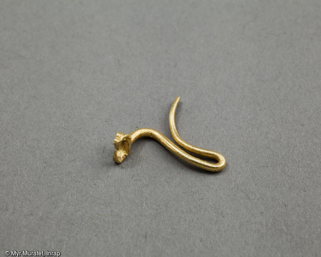 Boucle d'oreille en or, formée d'une seule pièce, longueur 1,5 cm, 2e moitié du IIIe-IVe siècle, découvert sur le site archéologique de la place De Gaulle à Orléans (Loiret). Elle était portée à droite, l'attache filiforme se termine par deux branches repliées, probablement destinées à enserrer un élément aujourd'hui disparu (pierre, perle etc...).