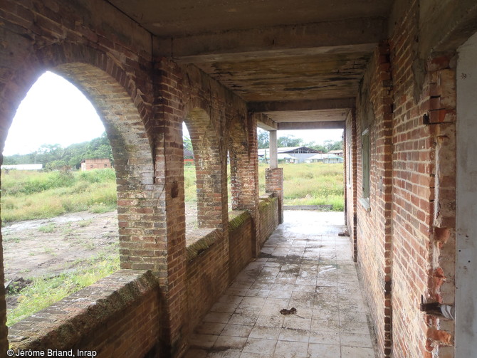 Aper&ccedil;u de la galerie desservant la caserne des surveillants du camp p&eacute;nitentiaire de Saint-Maurice &agrave; Saint-Laurent-du-Maroni (Guyane). Cette galerie ouverte, agr&eacute;ment&eacute;e d'une succession d'arches reposant sur un mur-bahut. De cette galerie partait un escalier desservant l'&eacute;tage aujourd'hui disparu.