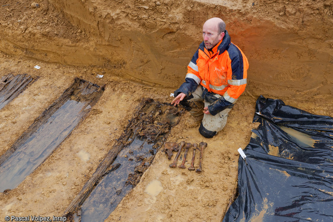 Une fosse collective contenant environ 65 soldats de la Grande Guerre mise au jour dans le cimeti&egrave;re provisoire fran&ccedil;ais &agrave; Spincourt (Meuse). Le responsable de fouille devant un ossuaire contenant 4 ou 5 d&eacute;funts. 