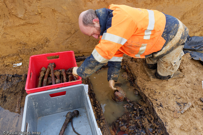 Pr&eacute;l&egrave;vement des os dans un ossuaire d'une fosse collective dans le cimeti&egrave;re provisoire fran&ccedil;ais de la Grande Guerre &agrave; Spincourt (Meuse). Un cr&acirc;ne de soldat vient d'&ecirc;tre mis au jour.