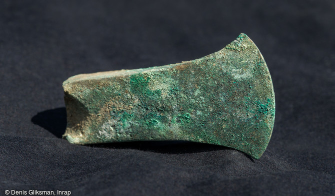   Fragment distal d'une hache &agrave; aileron du Bronze final d&eacute;couvert dans la fosse du d&eacute;p&ocirc;t d'objets m&eacute;talliques au cours de la fouille sur le Mont Castel &agrave; Port-en-Bessin (Calvados)    