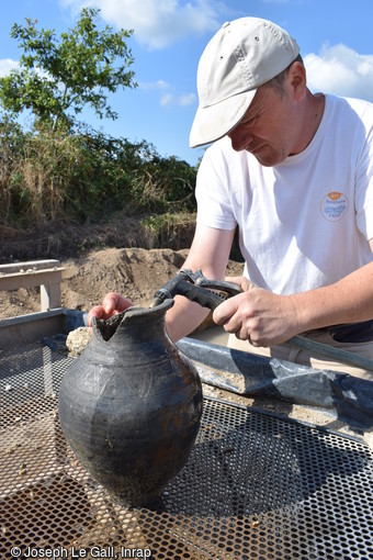 Nettoyage d'un vase de la fin de l'Antiquit&eacute; mis au jour dans le comblement d'un puits associ&eacute; au second habitat gallo-romain sur le site arch&eacute;ologique de la Zac de Brestivan &agrave; Theix-Noyalo (Morbihan).