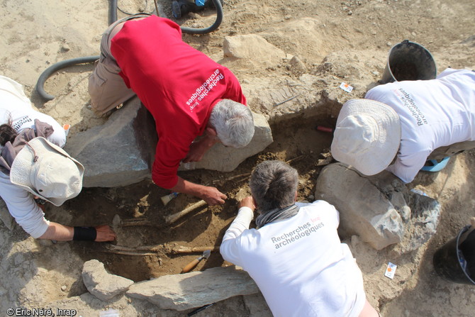 Fouille en cours d'une tombe de femme entour&eacute;e de dalles, de la fin de l'&acirc;ge du Bronze &agrave; Massongy (Haute-Savoie). Elle avait autour du cou un collier de perles d'ambre.
