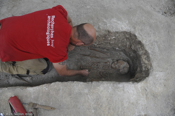 Fouille manuelle d'une s&eacute;pulture catholique &agrave; l'aide d'outils de dentiste sur le site arch&eacute;ologique du temple Saint-Eloi &agrave; Rouen (Seine-Maritime).
