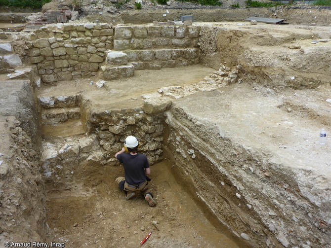 Fondation de la fa&ccedil;ade ouest de l&rsquo;&eacute;glise de l&rsquo;abbaye de Toussaints du XVIe si&egrave;cle &agrave; Ch&acirc;lons-en-Champagne (second plan) et mur associ&eacute; &agrave; la voirie du bas Moyen-&Acirc;ge (premier plan). Les fondations de l&rsquo;&eacute;glise sont massives, en moellons et blocs de craie, et solidement ancr&eacute;es dans le sol puisqu&rsquo;elles se d&eacute;veloppent sur pr&egrave;s de 2 m&egrave;tres de profondeur. 