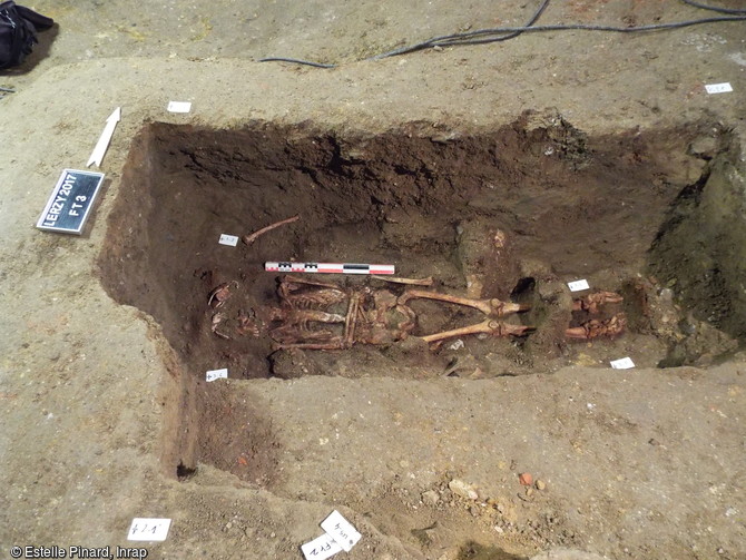 Vue g&eacute;n&eacute;rale d'une s&eacute;pulture d'&eacute;poque moderne, mise au jour dans le ch&oelig;ur de l'&eacute;glise Sainte-Benoite de Lerzy (Aisne). Les contraintes sur les hum&eacute;rus et les genoux t&eacute;moignent de l'enveloppement conjoint du corps. De nombreux clous en fer marquent l'emplacement d'un cercueil. 