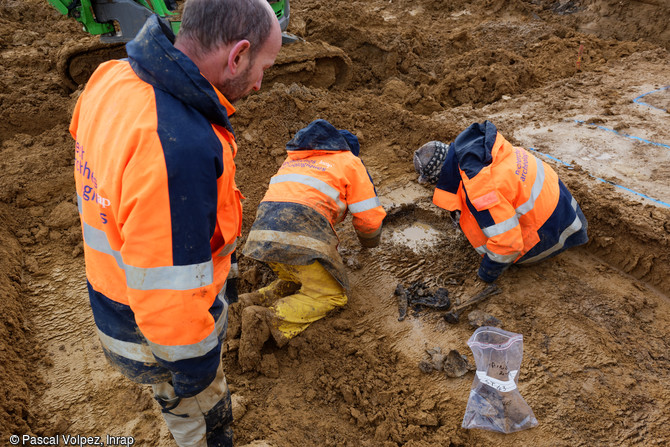 Fond d'un ossuaire en cours de fouille sur le site de la n&eacute;cropole provisoire de la Grande Guerre &agrave; Spincourt (Meuse). Quelques os et &eacute;l&eacute;ments d'uniforme d'un d&eacute;funt sont encore l&agrave;.