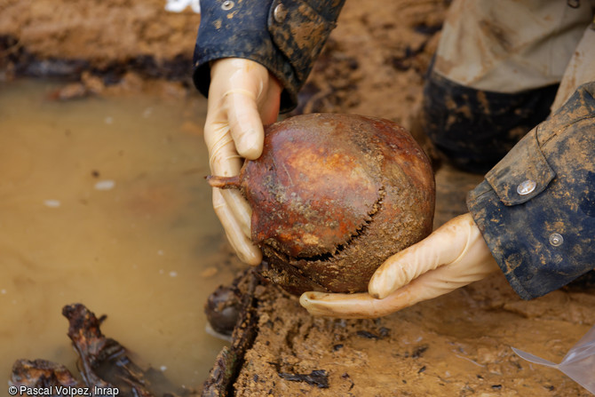 Pr&eacute;l&egrave;vement d'un cr&acirc;ne dans un ossuaire de l'une des fosses multiples sur le site de la n&eacute;cropole provisoire de la Grande Guerre &agrave; Spincourt (Meuse).