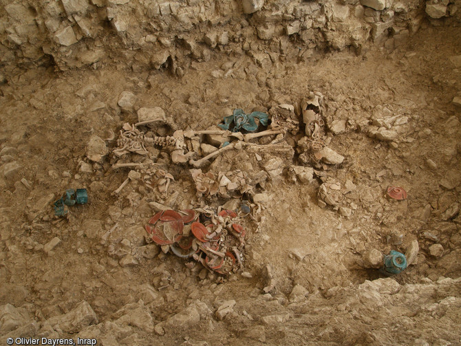 Détail d'un individu inhumé à l'est de la grande fosse, mis au jour à L'Houmeau (Charente-MarItime), 2009. La fouille, a mis en évidence un chai antique, des espaces d'inhumation antiques et médiévaux et un habitat du haut Moyen Âge. L'organisation des dépôts (attribués à la seconde moitié du IIe siècle) et leur très bonne conservation suggèrent la présence de contenant.  