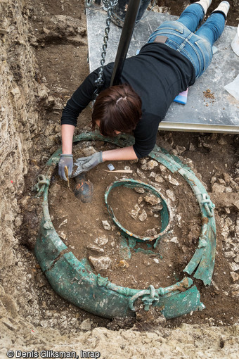 EN SUSPENSION      Perchée au-dessus de la zone de fouille sur une planche, l’archéologue dégage délicatement un magnifique chaudron  en bronze du début du Ve siècle avant notre ère. Des précautions à la hauteur d’un complexe funéraire monumental exceptionnel : la sépulture du prince celte  de Lavau dans l’Aube. 