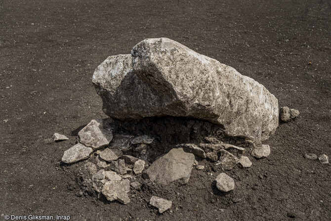 Monolithe de calcaire encore partiellement dress&eacute; et fragment&eacute; sur place sur le site de Veyre-Monton (Puy-de-D&ocirc;me) en cours de fouille en 2019. A l'image de certains monuments, dont Belz dans le Morbihan, les menhirs de Veyre-Monton ont &eacute;t&eacute; intentionnellement abattus (changement de communaut&eacute; ? de croyances ?). L'occupation du site s'inscrit sur un temps long couvrant plusieurs mill&eacute;naires, du N&eacute;olithique &agrave; l'&acirc;ge du Bronze. 