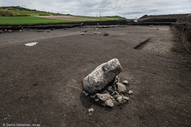 Monolithe de calcaire encore partiellement dress&eacute; et fragment&eacute; sur place sur le site de Veyre-Monton (Puy-de-D&ocirc;me) en cours de fouille en 2019. A l'image de certains monuments, dont Belz dans le Morbihan, les menhirs de Veyre-Monton ont &eacute;t&eacute; intentionnellement abattus (changement de communaut&eacute; ? de croyances ?). L'occupation du site s'inscrit sur un temps long couvrant plusieurs mill&eacute;naires, du N&eacute;olithique &agrave; l'&acirc;ge du Bronze.