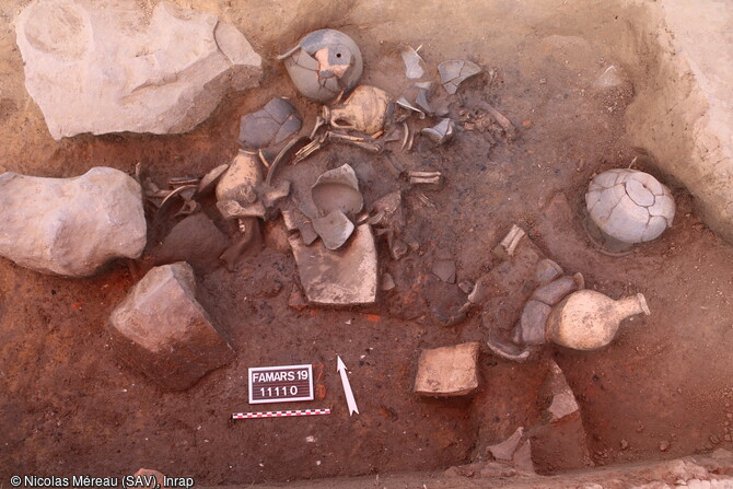 D&eacute;p&ocirc;t votif de vases et d'offrandes alimentaires de gibier, de cochon et de poisson. Les pots &agrave; cuire sont pos&eacute;s sur leur ouverture et perc&eacute; dans le fond. Les cruches comprenaient un galet dispos&eacute; dans la cruche avant cuisson attestant d'une production sp&eacute;cifique destin&eacute;e au c&eacute;r&eacute;moniel.