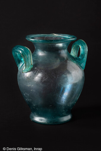 Vase ossuaire en verre contenant des fragments osseux br&ucirc;l&eacute;s, et dans le fond une bague en or, mis au jour dans la n&eacute;cropole antique de Narbonne (Aude) en 2019. 