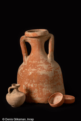 Conduit &agrave; libation constitu&eacute; d'une partie d'amphore, avec cruche et coupelles en c&eacute;ramique mis au jour dans la n&eacute;cropole antique de Narbonne (Aude) en 2019. Rarement attest&eacute; en Gaule, l'usage de conduits &agrave; libation concerne une tombe sur trois &agrave; Narbonne. D&eacute;passant du sol, ces conduits sont des c&eacute;ramiques, parfois des amphores, enfonc&eacute;es dans la tombe pour arriver au plus pr&egrave;s du d&eacute;funt. Ils permettent d'y introduire des offrandes. Certains renferment encore des coupelles ayant servi aux libations comme ici. 