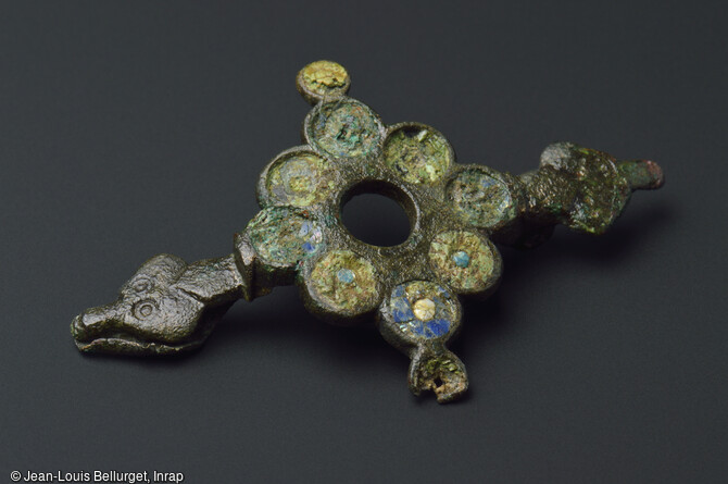 Fibule en bronze avec incrustations d'&eacute;mail, 250-400 de notre &egrave;re, mise au jour lors de la fouille de la Zac Pasteur &agrave; Besan&ccedil;on (Doubs) entre 2010 et 2011. La fibule est une sorte de broche servant &agrave; agrafer les v&ecirc;tements, le bouton n'apparaissant qu'au Moyen &Acirc;ge. 