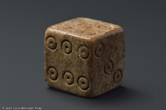 D&eacute; &agrave; jouer en os, 80-150 de notre &egrave;re, d&eacute;couvert lors de la fouille de la Zac Pasteur &agrave; Besan&ccedil;on (Doubs) entre 2010 et 2011. Les jeux de hasard ou les jeux d'argent utilisant des d&eacute;s &eacute;taient tr&egrave;s populaires &agrave; l'&eacute;poque gallo-romaine. 