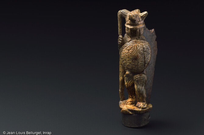 Canif &agrave; manche en ivoire, IVe si&egrave;cle, mis au jour lors de la fouille de la Zac Pasteur &agrave; Besan&ccedil;on (Doubs) entre 2010 et 2011. Ce petit couteau de poche &agrave; lame pliante pr&eacute;sente un manche d&eacute;cor&eacute; d'un gladiateur arm&eacute; et casqu&eacute; au combat. 