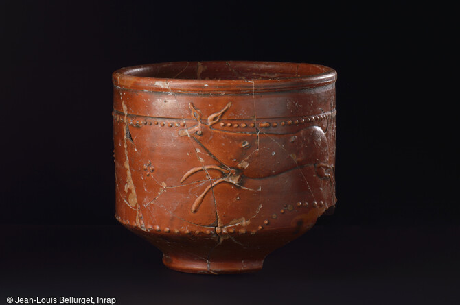 Gobelet en terre cuite sigill&eacute;e d&eacute;cor&eacute; d'une sc&egrave;ne de chasse, 2e moiti&eacute; du IIIe si&egrave;cle. Mis au jour lors de la fouille de la Zac Pasteur &agrave; Besan&ccedil;on (Doubs) entre 2010 et 2011.