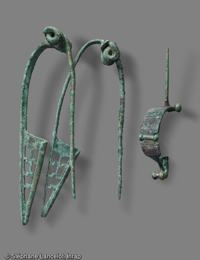 Les deux fibules de gauche ont &eacute;t&eacute; retrouv&eacute;es associ&eacute;es &agrave; une rondelle dentel&eacute;e dans un vase &agrave; incin&eacute;ration. Fibule de droite Feug&egrave;re dat&eacute;e de l'&eacute;poque august&eacute;enne, vers 10 avant notre &egrave;re. Mises au jour lors de la fouille &agrave; Saint-Sauveur (Somme) en 2015. 