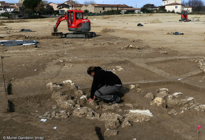 Fouille du soubassement d'un mur en pierre d'un b&acirc;timent du Bronze ancien &agrave; Saint-Geni&egrave;s-de-Fontedit (H&eacute;rault) en 2022. Une portion de mur permet de reconna&icirc;tre l'extr&eacute;mit&eacute; en abside d'un imposant b&acirc;timent mesurant 6 m de large pour une longueur qui devait d&eacute;passer 10 m. Seule les premi&egrave;res assises devaient &ecirc;tre en pierre. Ce mat&eacute;riau, qui offre une meilleure r&eacute;sistance, est souvent privil&eacute;gi&eacute; pour les parties basses des murs, les parties hautes &eacute;taient en bois et en terre crue. Cette d&eacute;couverte documente pour la premi&egrave;re fois la forme des maisons du d&eacute;but de la Protohistoire dans les plaines 