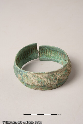 Vue de d&eacute;tail d'un anneau de cheville en alliage cuivreux port&eacute; par un d&eacute;funt dans la n&eacute;cropole de l'&acirc;ge du Fer &agrave; Blainville-sur-Orne (Calvados) en 2021.