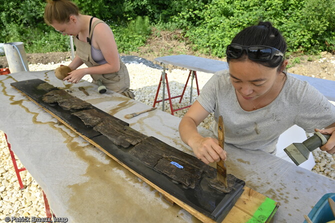 Lavage d'un &eacute;l&eacute;ment du plancher de l'&eacute;pave du bateau du haut Moyen &Acirc;ge (VIIe-VIIIe si&egrave;cles) d&eacute;couverte &agrave; Villenave-d'Ornon (Gironde) en 2022. La pr&eacute;sence d'un plancher indique que cette embarcation pouvait transporter des marchandises en vrac. 