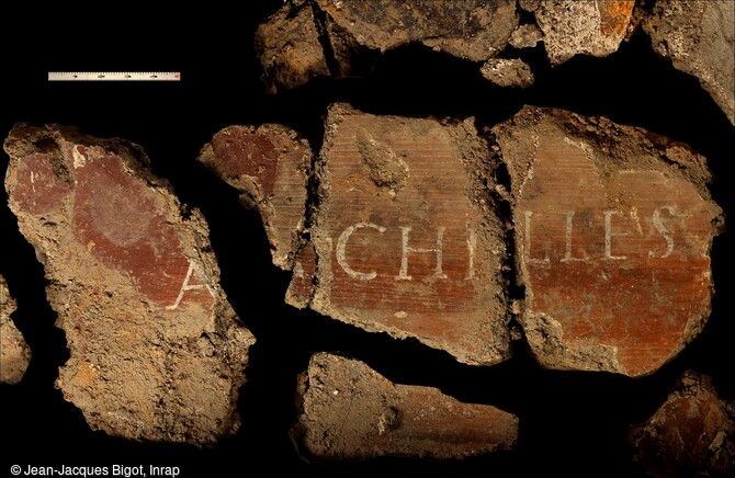 Fragments d'enduits peints, avec certaines inscriptions, il pourrait s'agir de la figure mythologique d'Achille, h&eacute;ros l&eacute;gendaire de la Guerre de Troie. Mis au jour dans la maison romaine des IIe-IIIe si&egrave;cles &agrave; Reims (Marne), ces peintures murales attestent que nous sommes dans l'habitation de gens lettr&eacute;s et financi&egrave;rement ais&eacute;s. 