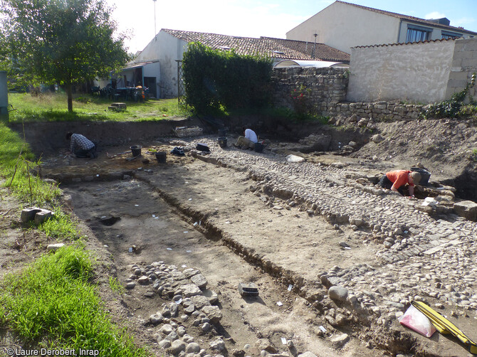 Vue g&eacute;n&eacute;rale de la calade de la cour int&eacute;rieure au centre de la parcelle conserv&eacute;e &agrave; droite et des niveaux de sol inf&eacute;rieurs recevant les trous de poteaux (XVIe-XVIIe s.) rue Pousse-Mesnil &agrave; Brouage, (Charente-Maritime).