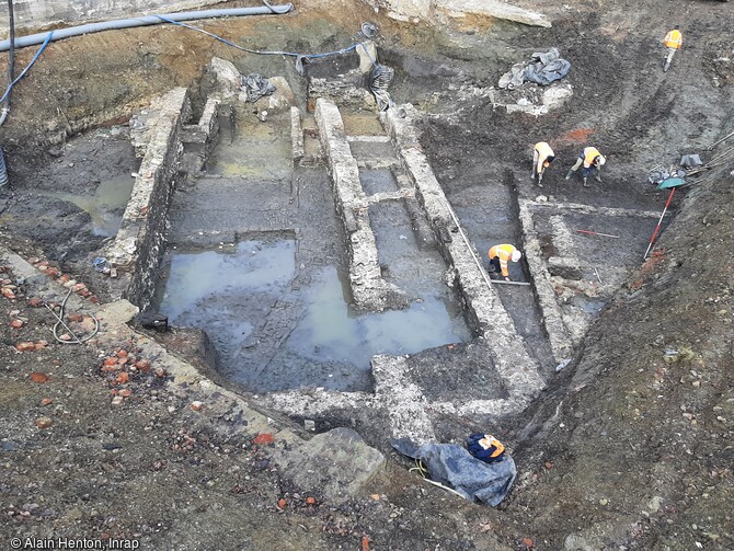 Béguinage. Lors du démontage du bâtiment du 16e siècle, seules les principales fondations puissantes de ce dernier ont été conservées. Entre celles-ci apparaît le niveau d’occupation du béguinage des 14e et 15e siècles, avec ses bâtiments et son réseau de chemins pavés, mis au jour à Maubeuge (Nord) en 2023. 