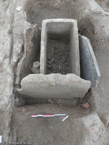 Coffrage mixte d'une tombe remployant une plaque fun&eacute;raire en marbre inscrite, d&eacute;couverte dans une n&eacute;cropole antique (1er au 3e si&egrave;cle) &agrave; Narbonne (Aude).Elle a livr&eacute; des vestiges fun&eacute;raires exceptionnels tant par leur nombre (pr&egrave;s de 500 tombes) que par leur &eacute;tat de conservation. La plupart des fosses abritent principalement des urnes fun&eacute;raires, la cr&eacute;mation &eacute;tant la pratique courante pour la p&eacute;riode, ainsi que du mobilier d'accompagnement.  