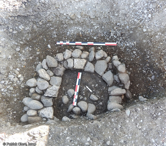 Sommet dégagé d'un puit médiéval (Xe s.). Localisé au centre du terrain, il a été aménagé dans une fosse de creusement de grande dimension (2.60 m de long).