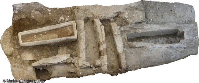 Vue générale du sarcophage monolithe et de plusieurs coffrages d'époque carolingienne après fouille dans l'ancienne église Saint-Genès à Clermont-Ferrand (Puy-de-Dôme).