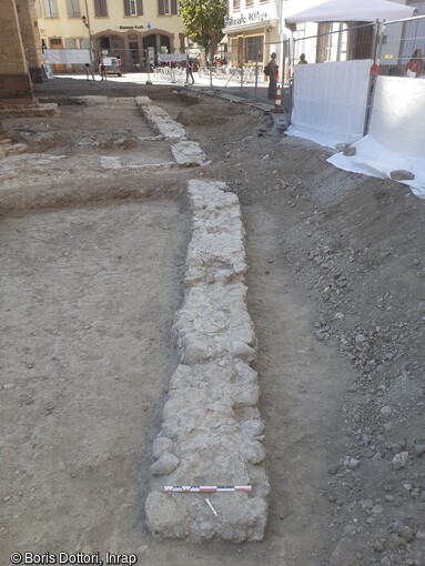 Mur d'enceinte du cimetière au niveau du parvis de la collégiale Saint-Martin à Colmar (Haut-Rhin). D'après les sources historiques, les bourgeois de Colmar vendent en 1212 un terrain communal pour financer la construction d'un mur de protection autour de l'église et de son cimetière. La fortification des cimetières était chose courante dans l'Alsace médiévale, région en proie à d'incessants conflits : elle permettait aux populations de se mettre à l'abri au sein d'un périmètre consacré, disposant du droit d'immunité (interdiction d'y commettre des actes de violence ou de contrainte)