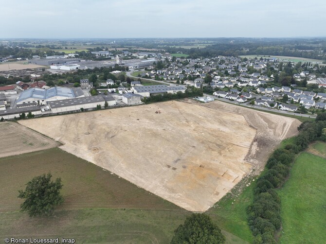 Vue aérienne du site de la fouille d'Argentré-du-Plessis (Ille-et-Vilaine) en 2023. Sur ce terrain couvrant plus de trois hectares, les archéologues ont mis au jour en ensemble de vestiges datant principalement de l'époque carolingienne. Ces vestiges ont été retrouvés dans des fosses ou fossés creusés dans la terre et comblés depuis. Des traces fugaces de bâtiments ou de clôtures ont également été découvertes.