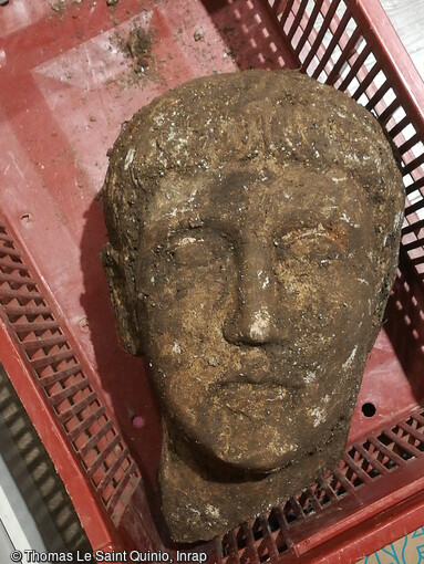 T&ecirc;te de la statue en calcaire, sortie de terre datant de la 1&egrave;re moiti&eacute; du 1er s. apr&egrave;s notre &egrave;re, &agrave; Briord (Ain) en 2020. Les traits id&eacute;alis&eacute;s sont celui d'un homme jeune et imberbe. 