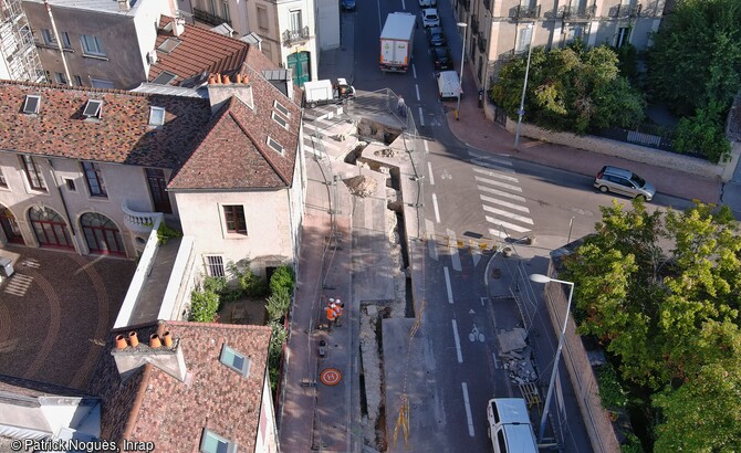 Vue par drone de la tranchée d'installation du réseau de chauffage urbain à l'intersection des rues Dietsch et Diderot à Dijon (Côtes-d'Or) en 2023. Ces tranchées ont été l'occasion pour les archéologues d'effectuer de nouvelles observations sur les fortifications médiévale et moderne ainsi que sur l'évolution de ce quartier situé au nord-est du centre historique.