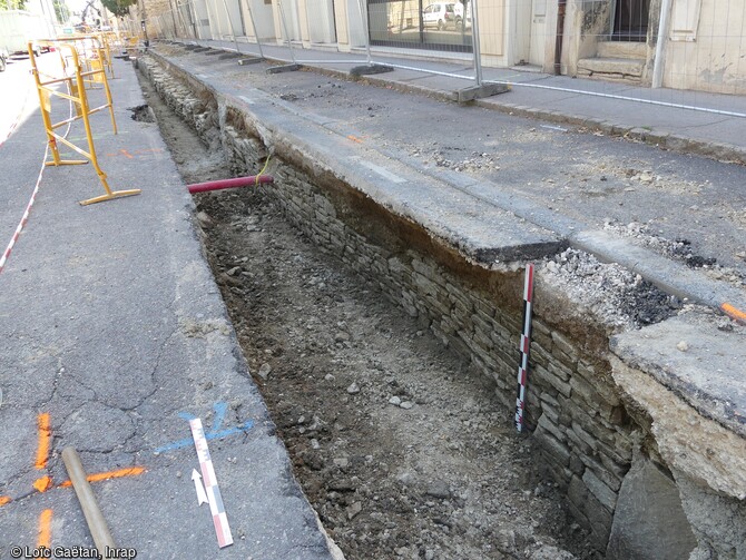 Tronçons du mur arrière du bâti médiéval, apparus dans la tranchée du réseau du chauffage urbain en cours de fouille à Dijon (Côtes-d'Or) en 2023. 