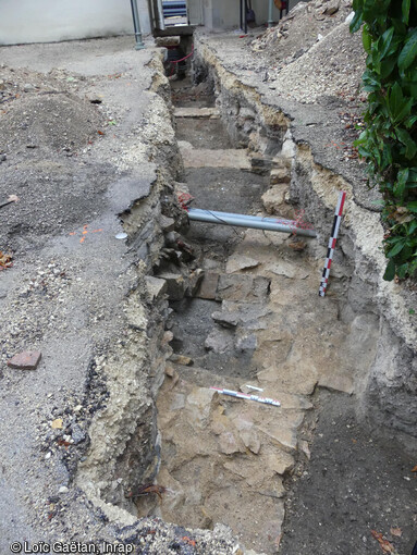 Vue générale de la tranchée dans la cour de la DRAC Bourgogne-Franche-Comté, recoupant les bâtiments des XVIIe-XIXe siècles, à l'arrière de l'hôtel Chartraire de Montigny, en cours de fouille à Dijon (Côtes-d'Or) en 2023.