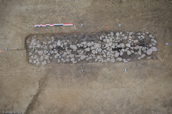 Probable bûcher funéraire avec un lit de cailloux recouvrant de nombreux brandons de bois, mis au jour dans la nécropole antique de Noyal-Châtillon-sur-Seiche (Ille-et-Vilaine). Ce bucher de forme rectangulaire de 4,05 m par 0,85 m est implanté au centre de l'enclos funéraire. Il est conservé sur une profondeur de 0,20 m au maximum 